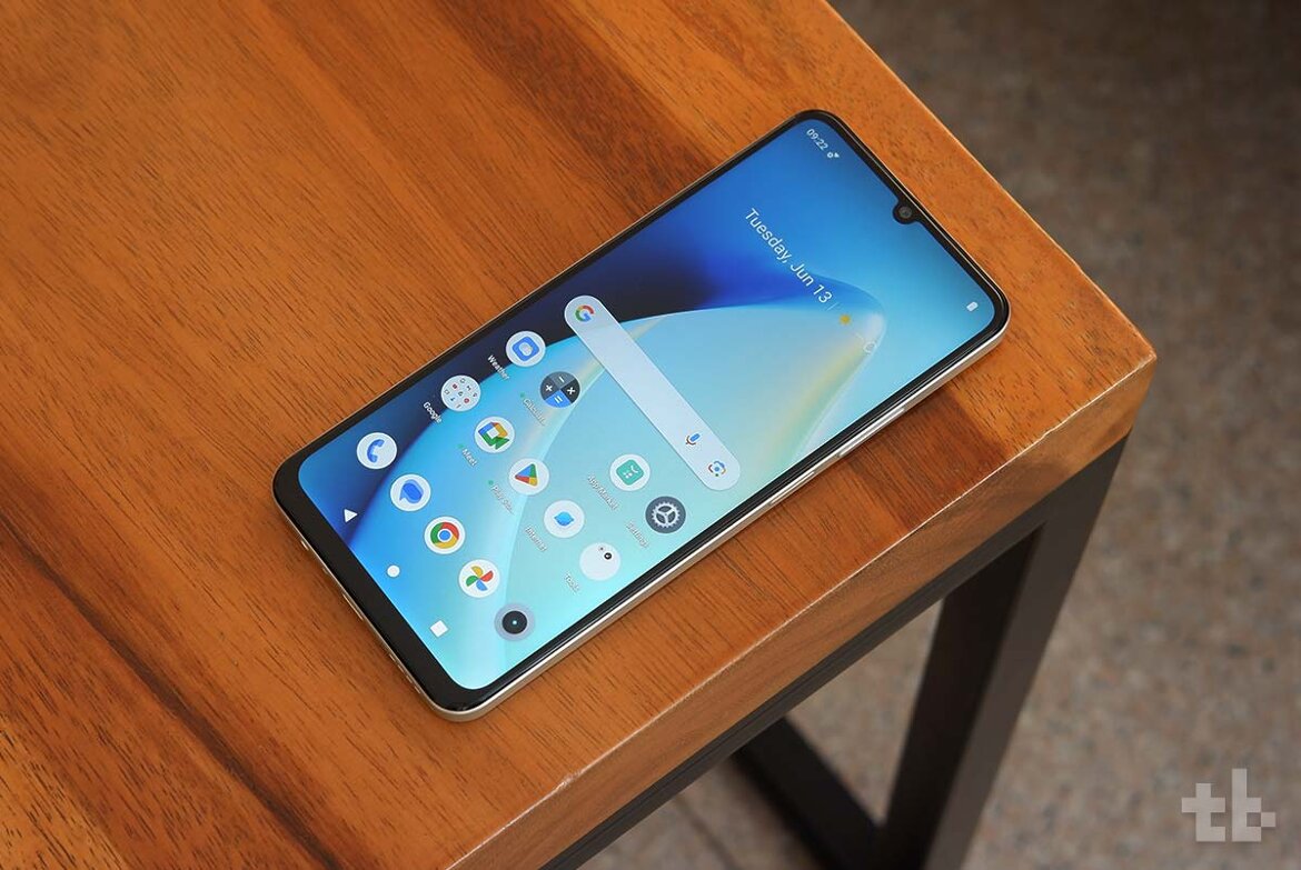  Realme C53 smartphone with a 6.74inch display and dual rear cameras is placed on a wooden table.